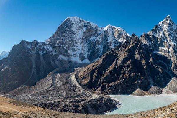 A landscape shot of beautiful Cholatse mountains next to a body of water in Khumbu, Nepal. Perfect for a wallpaper or a background.